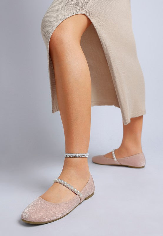 Side view of woman wearing pink Corphee Pearl Strapped Glitter Ballerinas with glitter finish and cushioned insole.