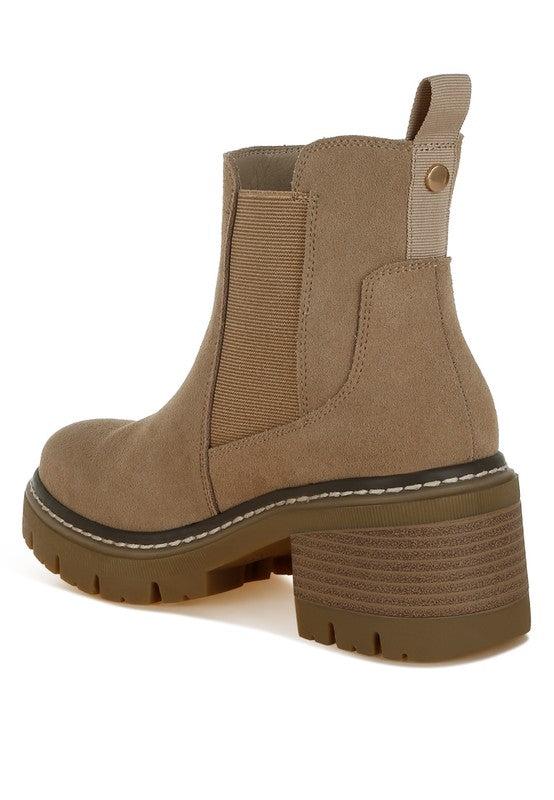 Beige Chelsea boots showing pull tab, heel, and anti-skid sole