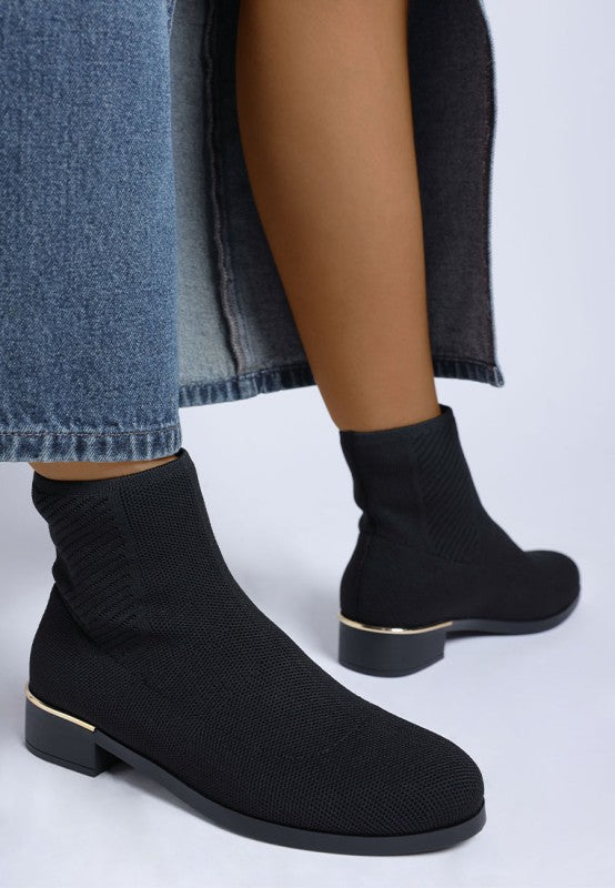 Side view of black Rosamund Sock Boots with metallic heel accent and sleek knit upper.