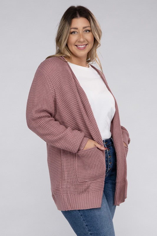 Curvy plus-size waffle-pattern open cardigan sweater in light rose, with long sleeves, oversized fit, and pockets.