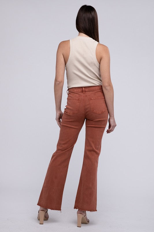 Rust acid-washed straight wide-leg pants featuring a frayed cutoff hem, zip fly closure, and a relaxed fit. Made with stretchy fabric for comfort and a unique vintage-inspired look.