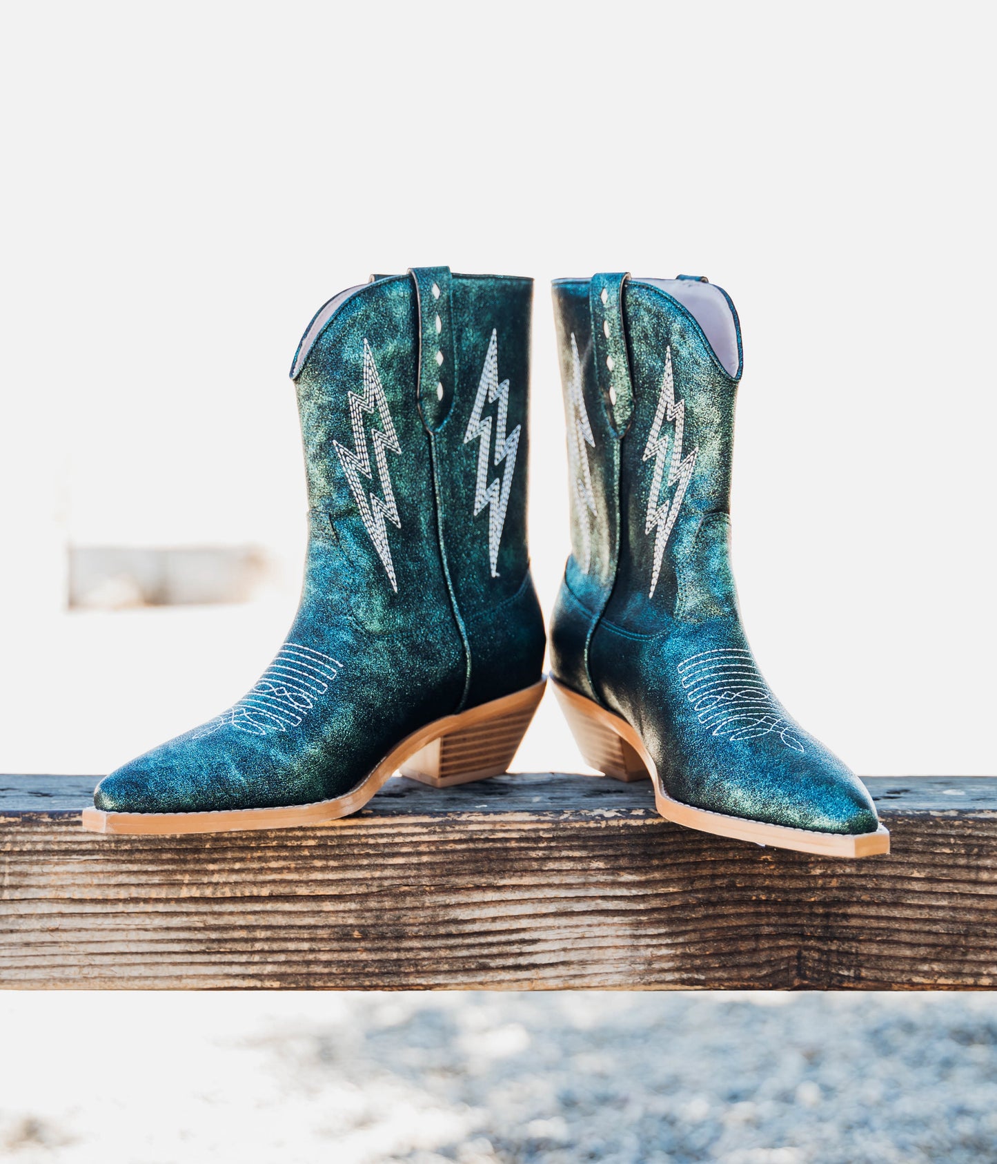 Teal mid-calf boots with a metallic finish, 10-inch shaft height, snip toe, 1.5-inch heel, and padded footbed.