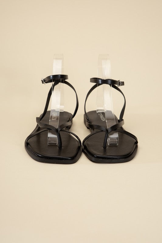 Black stylish strappy flat sandals with an open toe and square shape.