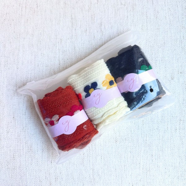 Packaged Side Garden Flower Socks Set of 3 with floral motifs in camel, white, and black.