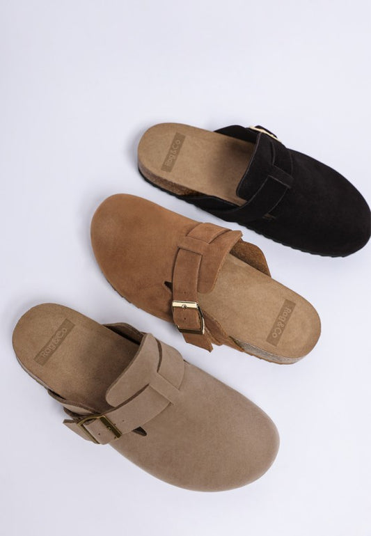 All three Ratiha Buckle Slip-On Mules side by side in taupe, tan, and black faux suede with gold buckle accent.