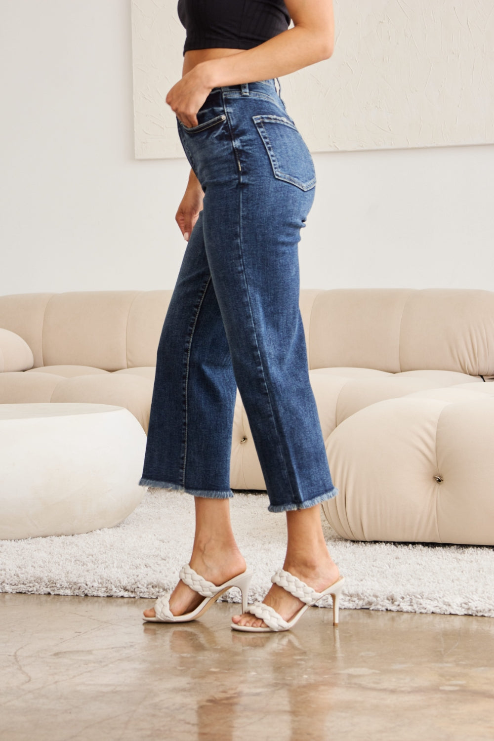 Dark wash high-waisted cropped jeans with tummy control, raw hem, and distressed details