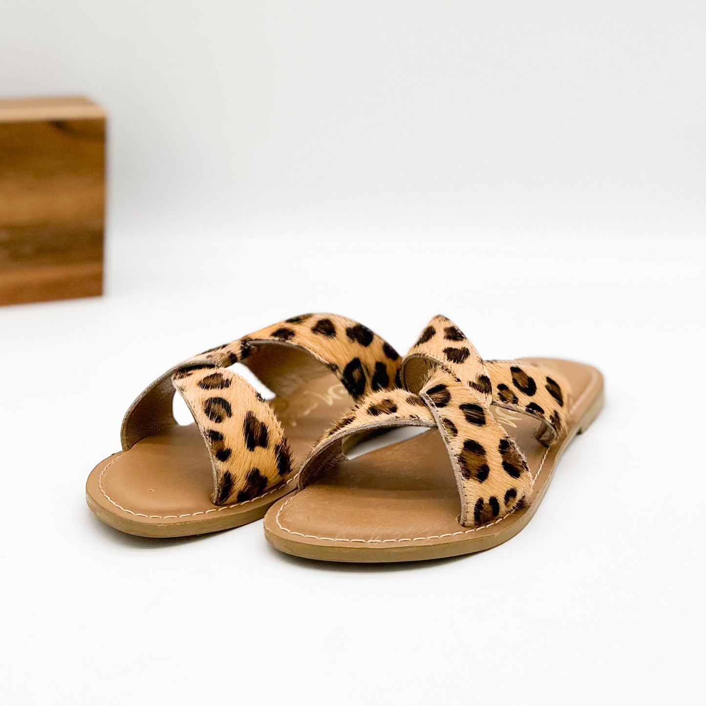 Leopard print hair-on-hide flat slide sandal with knotted upper and leather footbed by Naughty Monkey.