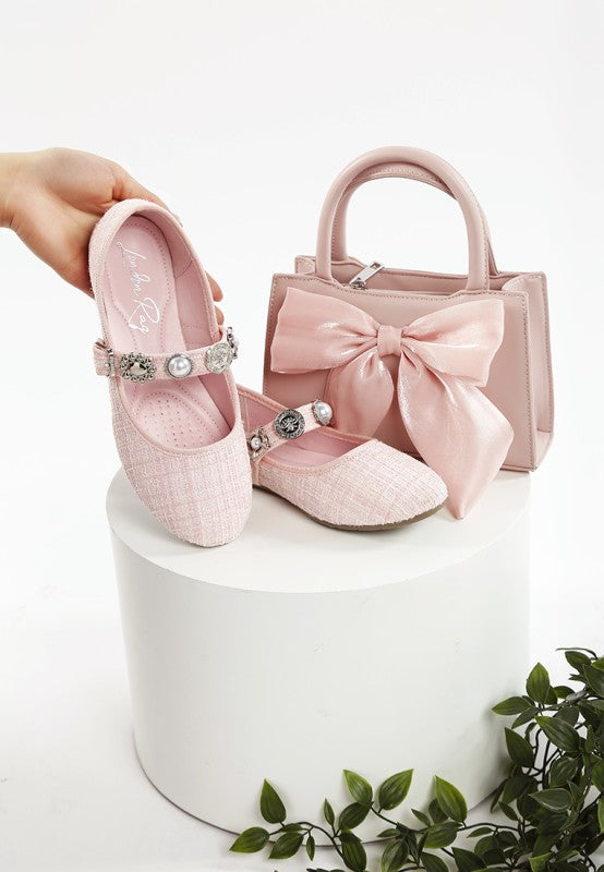 Pink Noyama Tweed Mary Janes with charm embellishments styled next to a matching pink purse for a chic, coordinated look.