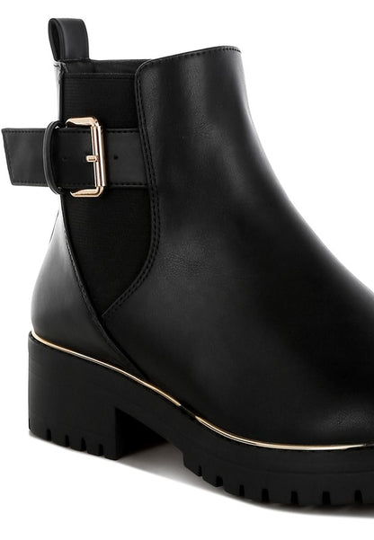 Close-up of black Antorin chunky buckle ankle boots showing textured vegan leather and buckle detail.