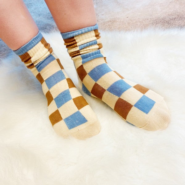 Woman wearing checkered Trendy Pattern Socks with bold brown and blue pattern.