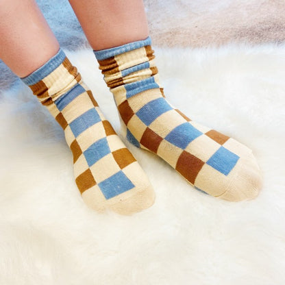 Woman wearing checkered Trendy Pattern Socks with bold brown and blue pattern.