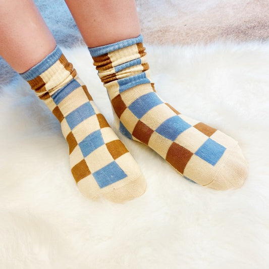 Woman wearing checkered Trendy Pattern Socks with bold brown and blue pattern.