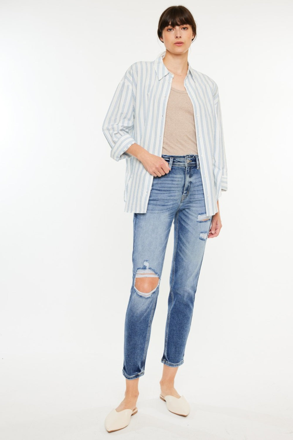 Medium wash high-rise mom jeans with distressed details and slightly stretchy fabric, offering a vintage-inspired, comfortable fit.