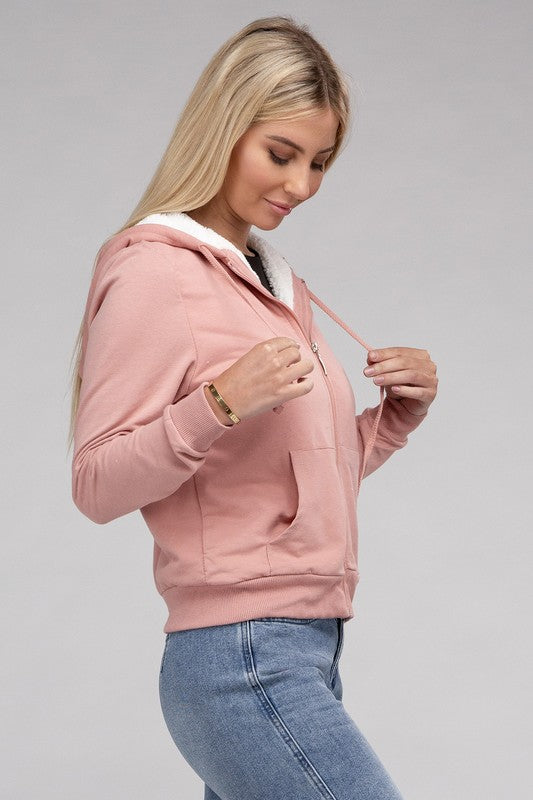 Mauve cropped zip-up hoodie with fuzzy trim, pockets, and long sleeves.