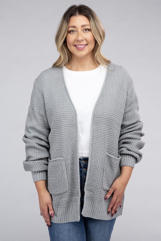 Curvy plus-size waffle-pattern open cardigan sweater in light grey, with long sleeves, oversized fit, and pockets.