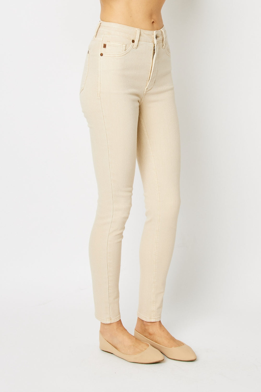 High-rise skinny jeans in bone with tummy control panel and zip fly. Slightly stretchy for comfort.