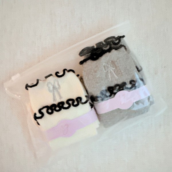 Packaged Ribbon Ripple Socks Set of 2 pairs in cream and grey variants.