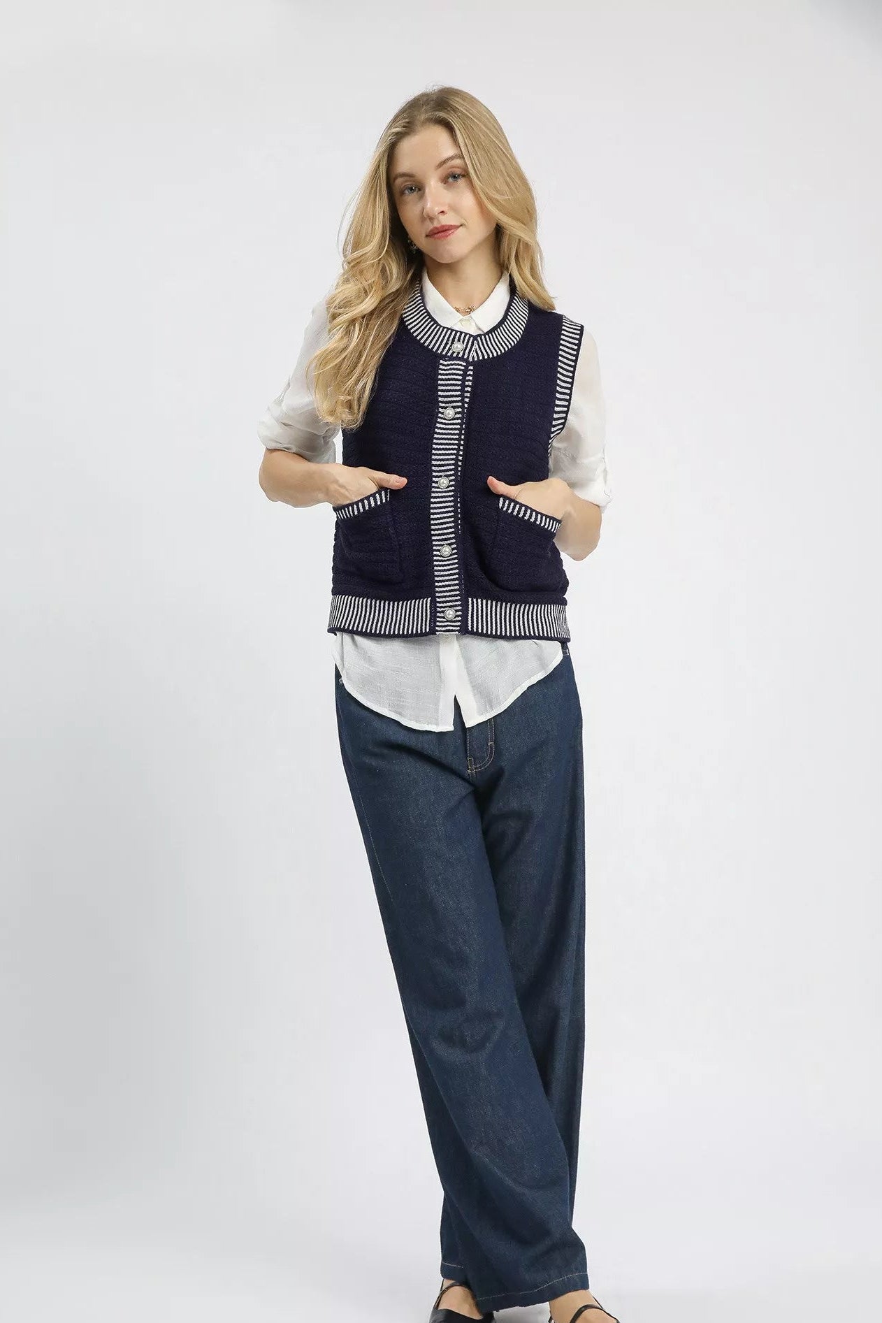 Model layering Mirren Sweater Vest over white blouse for a polished, preppy outfit.