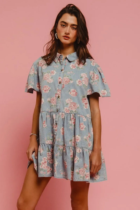 Front view of the Isla Floral Tiered Shirt Dress in light denim with pink blooms, tiered skirt, and flutter sleeves.