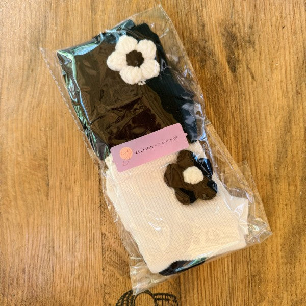 Packaged Puffy Daisy Embellished Socks Set of 2 with black and white variants.