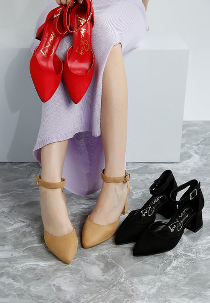 Woman wearing beige Rozita Block Heels holding red pair with black pair displayed nearby