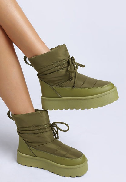 Model side pose showing khaki Pacos High Ankle Snow Boots and lug sole.