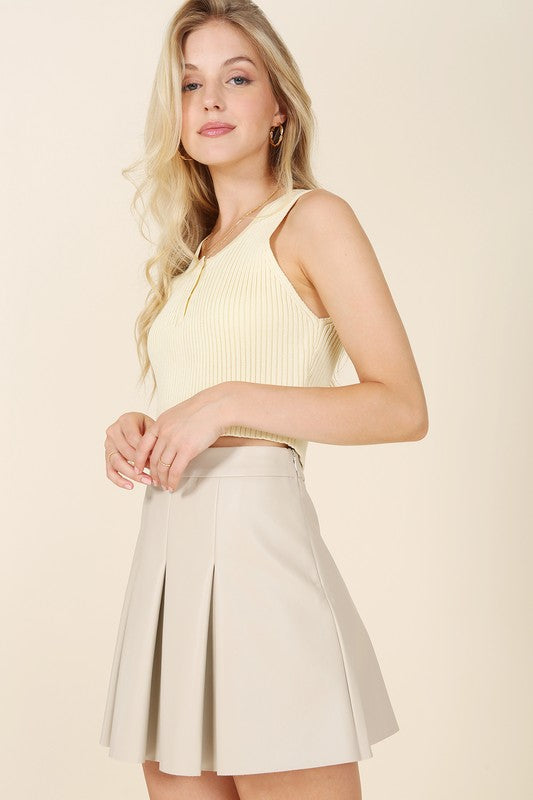 Ivory vegan leather pleated mini skirt with 4 pin tucks on the front and back for added style. Features a zipper closure.