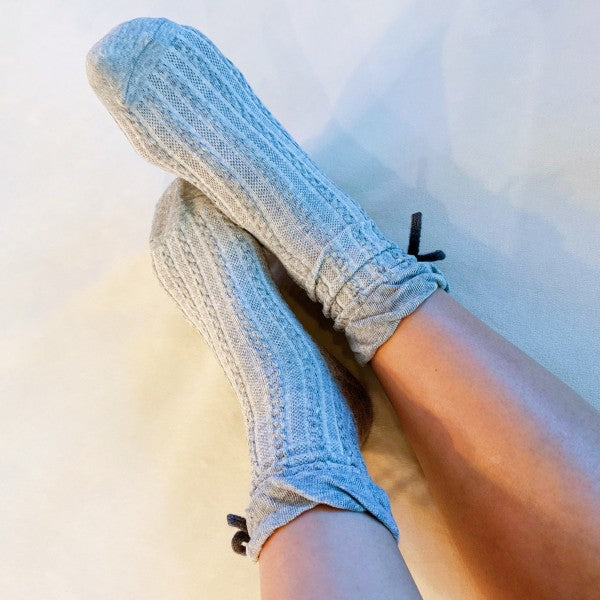 Model wearing grey Yarn Bow Socks highlighting cozy knit and bow accent.