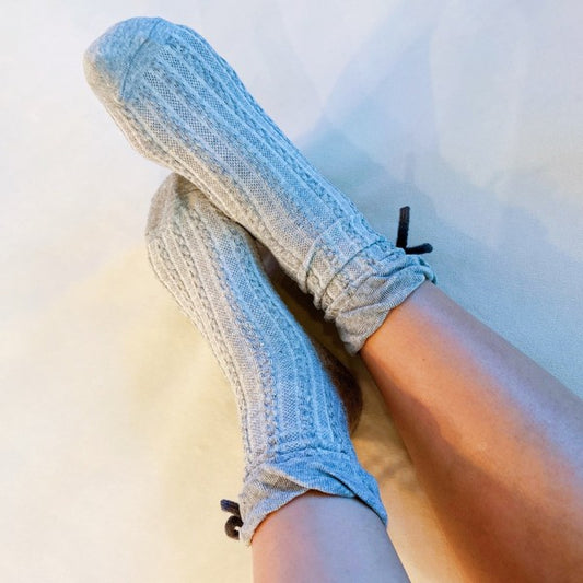 Model wearing grey Yarn Bow Socks highlighting cozy knit and bow accent.