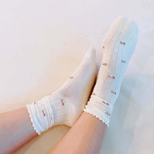 Woman wearing white Vintage Floral Socks styled with soft floral knit pattern.