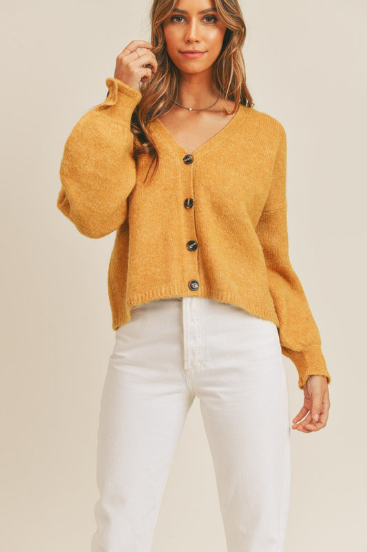 Women's mustard cardigan with a V-neckline, long sleeves, button-down closure, and a relaxed fit.