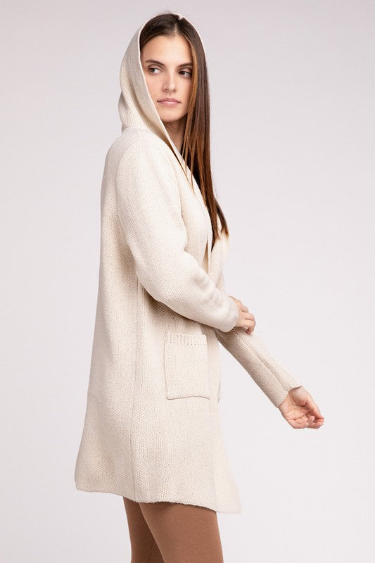 Sand Beige sweater cardigan with long sleeves, front pockets, and a hooded neckline. 