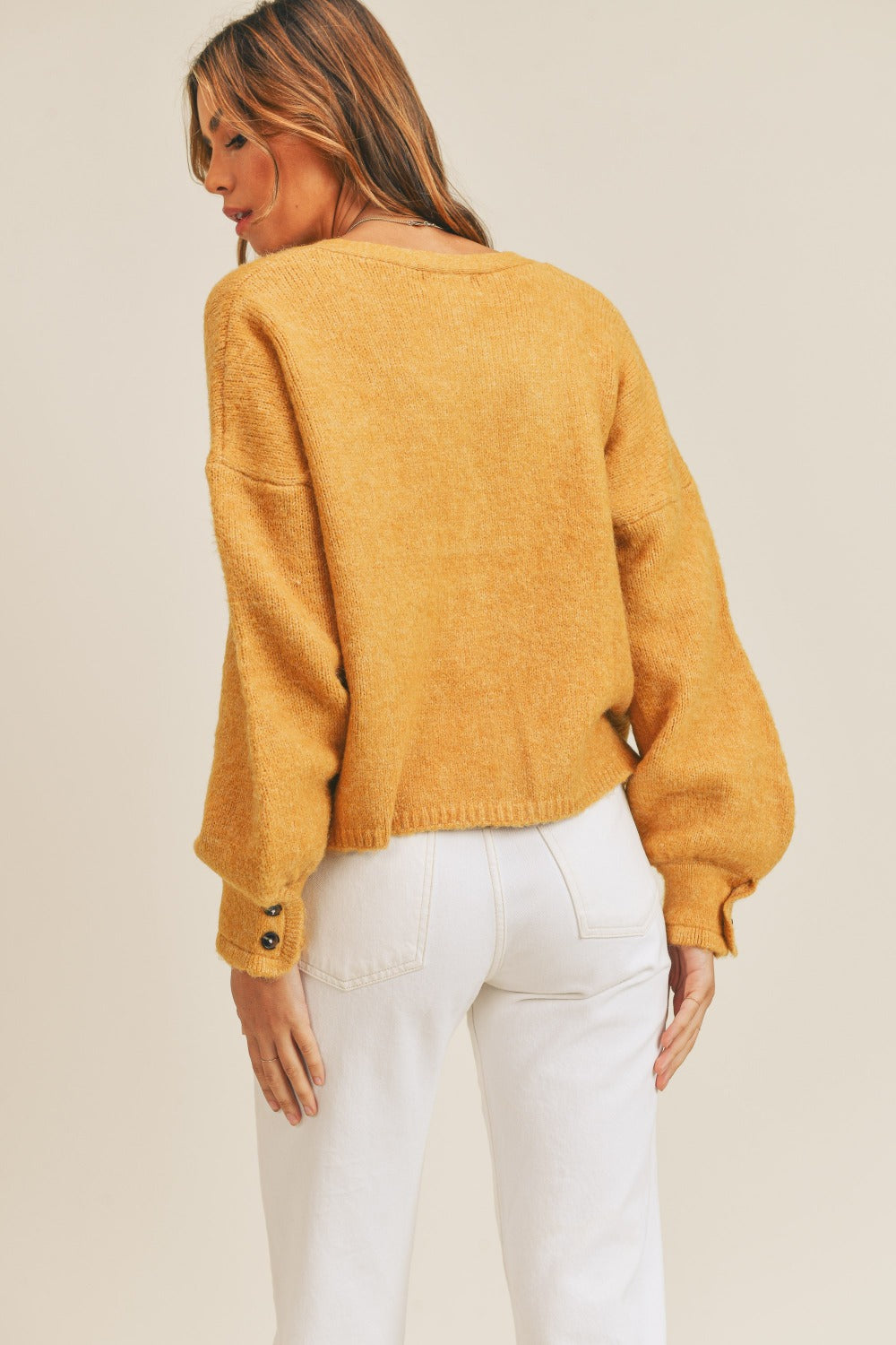 Women's mustard cardigan with a V-neckline, long sleeves, button-down closure, and a relaxed fit.