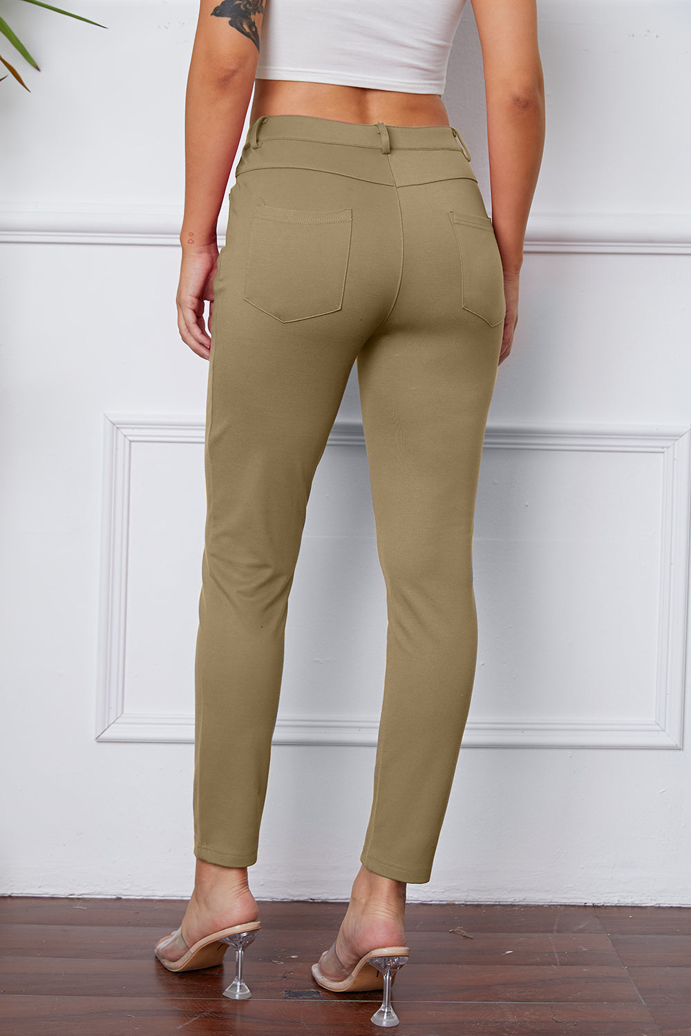 Khaki stretchy high-waisted pants feature pockets, a zip fly, and belt loops. 