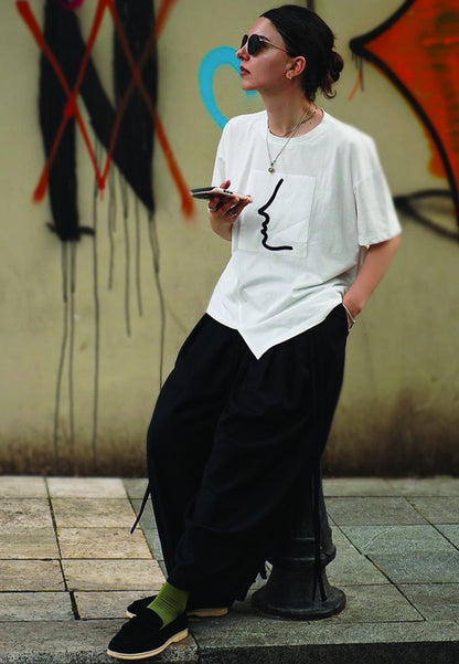 Woman wearing black Nautica suede loafers styled with relaxed streetwear.