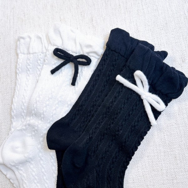 Flat lay of black and white Yarn Bow Socks set with contrasting yarn bows.