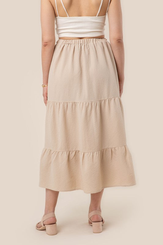 Tiered maxi skirt with elastic waistband in beige. Flowy silhouett, lined for full coverage.