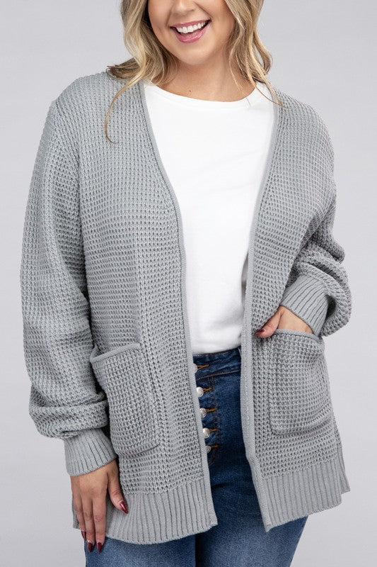 Curvy plus-size waffle-pattern open cardigan sweater in light grey, with long sleeves, oversized fit, and pockets.