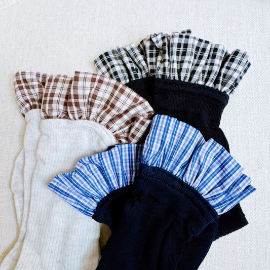 Flat lay of Oh So Chic Plaid Ruffle Socks in black, blue, and brown plaid with ruffle tops.