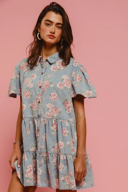 Close-up front view of Isla Floral Shirt Dress by BiBi, showing collared neckline, pink floral print, and tiered detailing on light denim fabric.