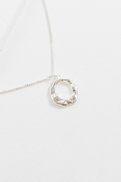 Flat lay of Charming Circle Necklace in Silver with textured pendant