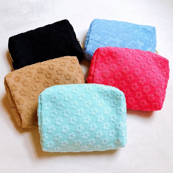 Overhead flat lay showcasing all color variants of the Embossed Daisy Blossom Cosmetic Case.