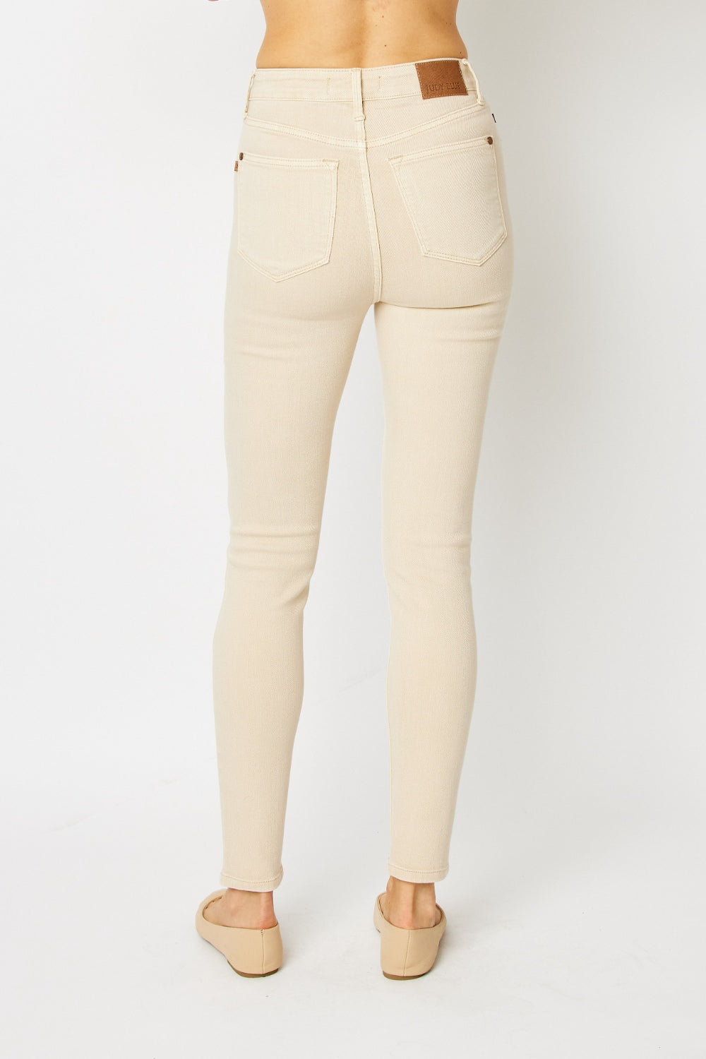 High-rise skinny jeans in bone with tummy control panel and zip fly. Slightly stretchy for comfort.