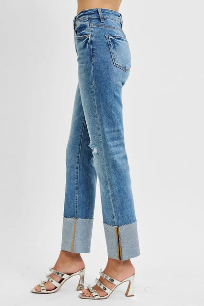 Side angle of Thea RISEN jeans featuring high rise, straight silhouette, and raw hem wide cuff.
