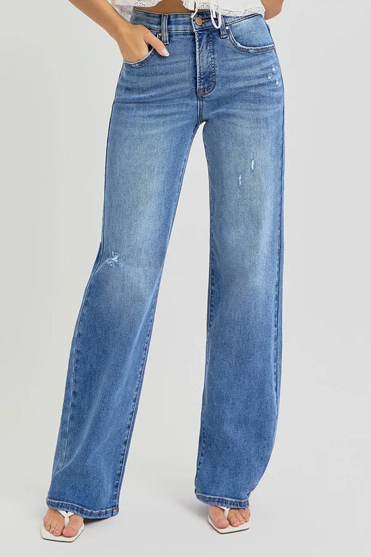 Plus size model wearing Allyson wide leg jeans in medium wash, hands relaxed at sides, showcasing high-rise fit and tummy control waistband.