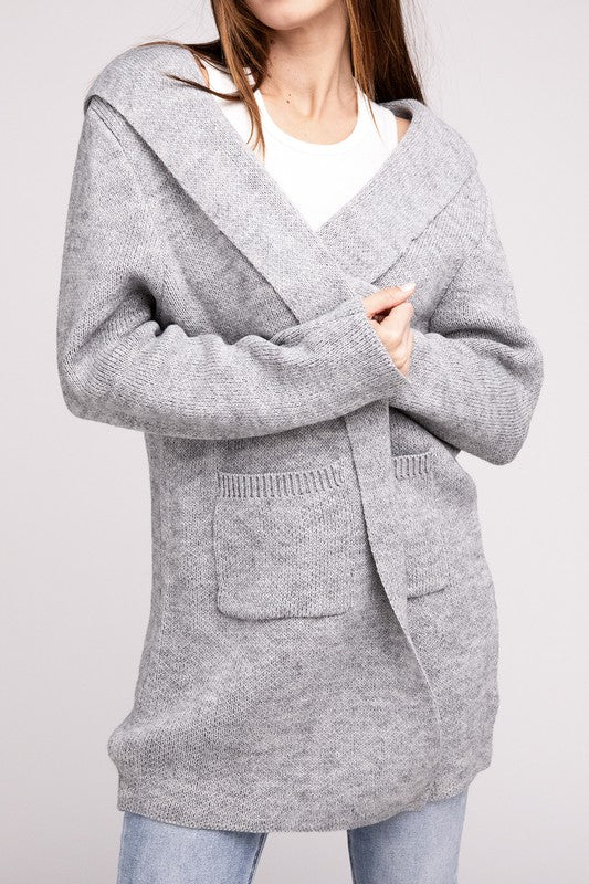 Grey sweater cardigan with long sleeves, front pockets, and a hooded neckline. 