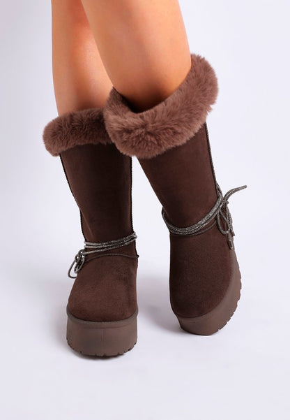Close-up of brown faux fur snow boots, showcasing microfiber texture and wraparound tie.