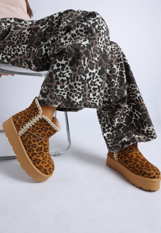 Model wearing Rochas Leopard Snow Boots side angle showing chunky flatform heel.