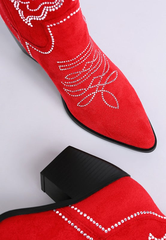 Close-up of pointed toe on red rhinestone cowboy boots with butterfly pattern