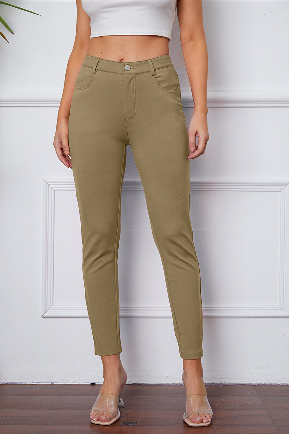 Khaki stretchy high-waisted pants feature pockets, a zip fly, and belt loops. 